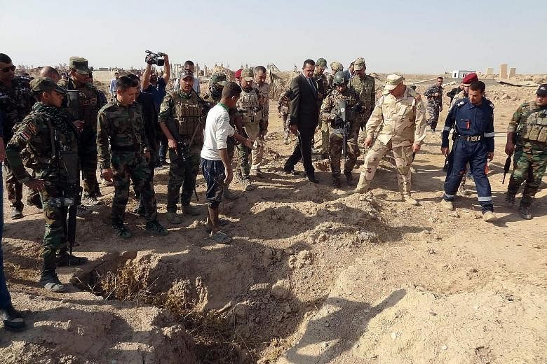 Iraqi forces searching the site of a suspected mass grave of victims killed by ISIS near a former military base, south-west of Hawija.