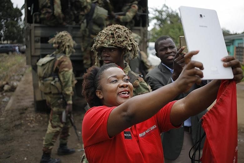 A women taking a selfie with soldiers at an anti-Mugabe rally organised by the War Veterans Association yesterday.