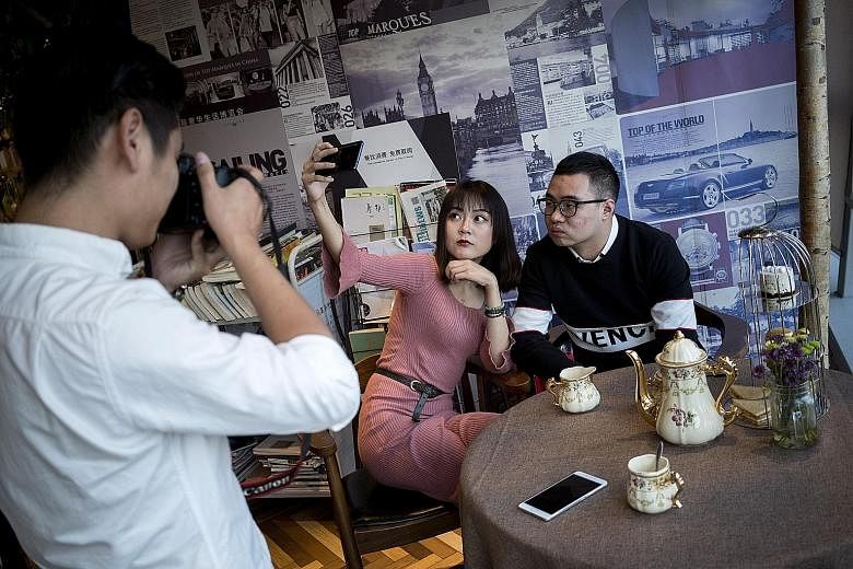 Mr Yu Ruitong taking a selfie with a woman while dating coach Zhang Mindong photographs them, during a session on getting good selfies for online dating profiles.