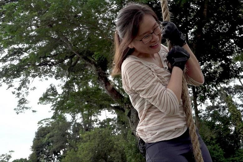 Straits Times journalist Ng Huiwen pulling herself up a rope, scaling a 1.5m-high wall (below), and going through a scenario-based drill - a simulated gunman attack (right) - with officers from the police's elite Emergency Response Team moving in to 