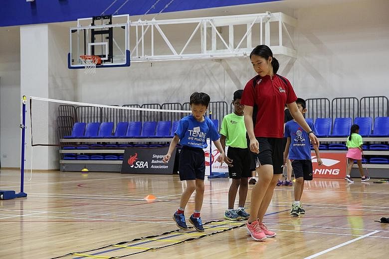 Team Singapore athlete Grace Chua showing some moves to children who experienced "Badminton and much more" at the inaugural SBA Badminton Academy @ ActiveSG Badminton Fiesta at Heartbeat@Bedok Badminton Sports Hall on Saturday. More than 100 students