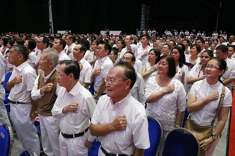 Left: Prime Minister Lee Hsien Loong and Mrs Lee taking a photo with party members yesterday. In his speech, PM Lee recapped the Government's work since it began its term in January last year, and outlined the work to come. Below: PAP members taking 