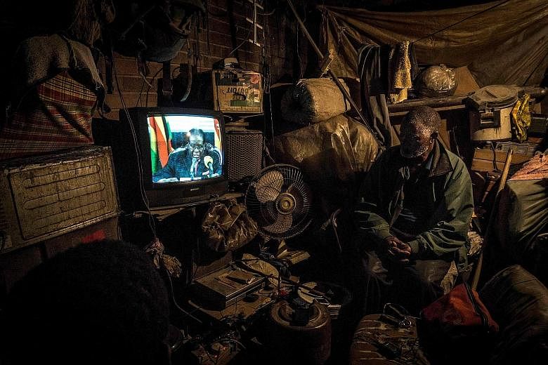 A man watching a televised address by Zimbabwe President Robert Mugabe in Mbare, Harare, on Sunday, when he was widely expected to announce that he was stepping down to enable Mr Emmerson Mnangagwa (above), who he had fired as vice-president earlier 