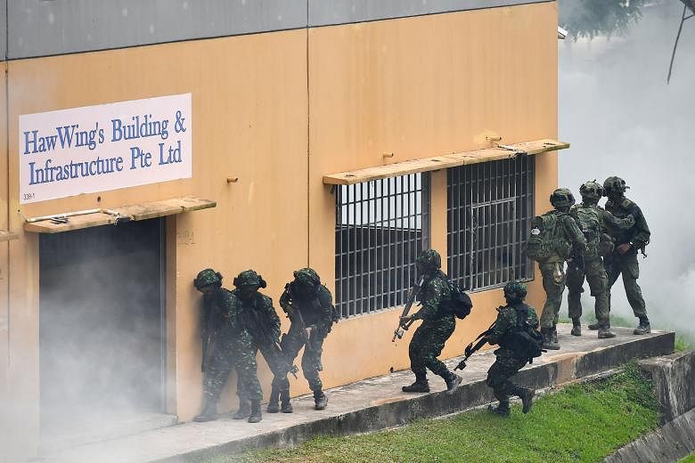 Singapore and Indonesian troops preparing to storm a building during their final troop exercise yesterday.
