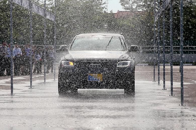 A Delphi self-driving car going through a rain simulator. The centre also has a flood zone to test the navigation abilities of autonomous vehicles in adverse weather.