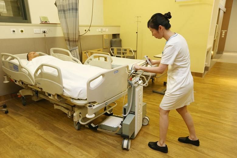 Left: CGH senior staff nurse Lee Sze Wen showing how a bed transporter is used. Piloted at CGH last year, the device will be in use at several public hospitals by mid-next year. Above: CGH deputy director of nursing Wong Kok Cheong said the transport