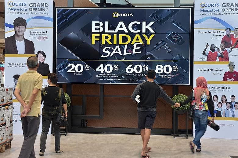 Courts Singapore put up signs at its Tampines megastore yesterday to alert shoppers to its Black Friday deals and offerings.