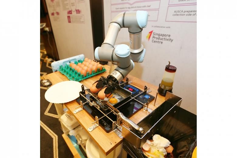 Technology on display at the Suntec Singapore Convention and Exhibition Centre yesterday included (from far left) a delivery robot solution to automate the transport of laundry in hotels and a robotic arm that cooks eggs for guests in three minutes.