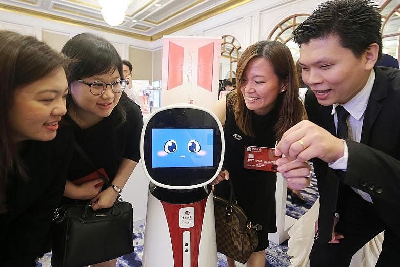 Bank of China's Singapore branch and SPH's Lianhe Zaobao launched the credit card yesterday at a ceremony featuring the bank's interactive robot.