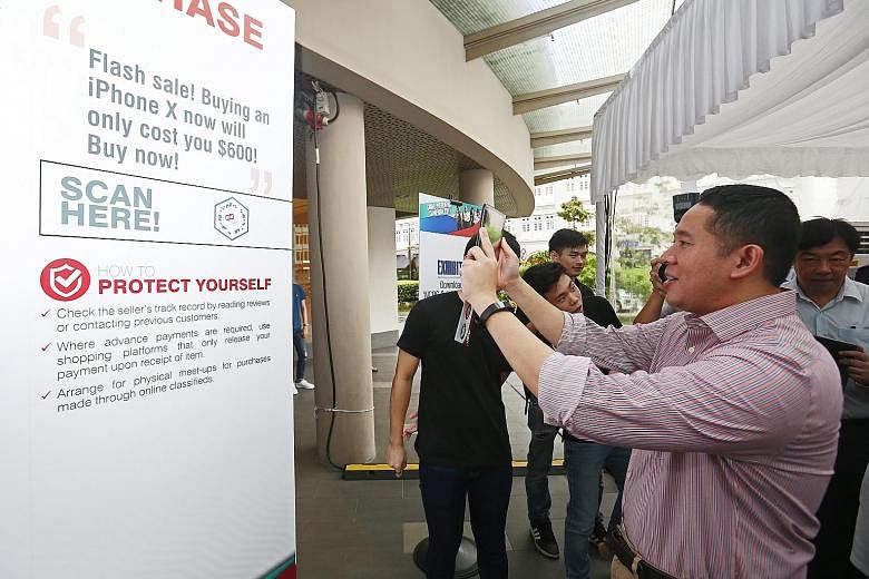 Parliamentary Secretary for Home Affairs and Health Amrin Amin at the launch of the police and National Crime Prevention Council's crime prevention campaign at Chinatown Point, where he checked out the exhibition, which focused on four common scams, 