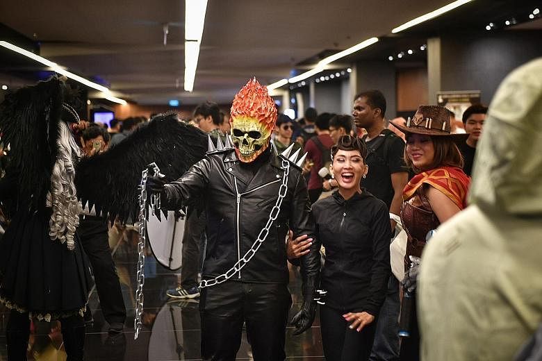 A cosplayer dressed as Marvel character Ghost Rider stopping to pose for photographers at the festival. Security officer Amirul Mok, 22, dressed as large squishy robot Baymax from the movie Big Hero 6, was a hit with the children. Ms Pamela Peh (far 