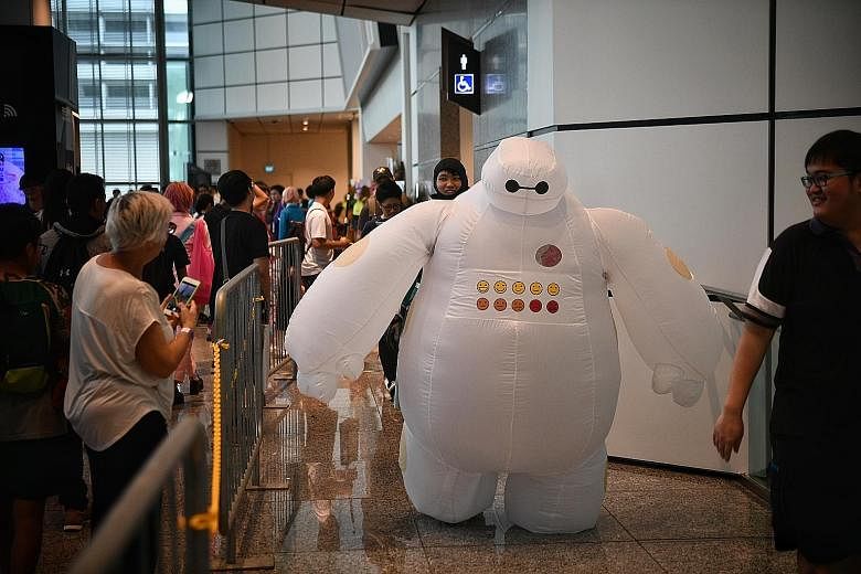 A cosplayer dressed as Marvel character Ghost Rider stopping to pose for photographers at the festival. Security officer Amirul Mok, 22, dressed as large squishy robot Baymax from the movie Big Hero 6, was a hit with the children. Ms Pamela Peh (far 