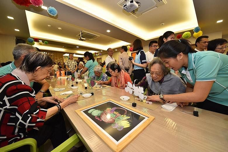Seniors at PCF's new Sparkle Care centre in Yew Tee engaging in an arts and crafts activity yesterday.