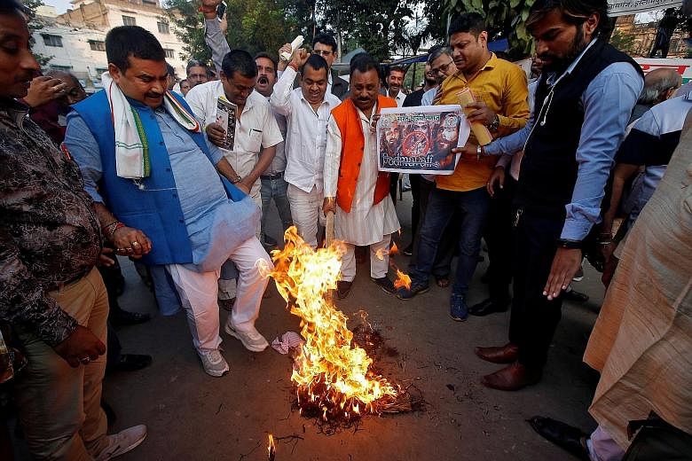 People burning an effigy of director Sanjay Leela Bhansali at a protest against the release of the movie, Padmavati, in Kolkata, on Wednesday. In the controversial movie, Rajput queen Padmavati was played by superstar Deepika Padukone, whose life has