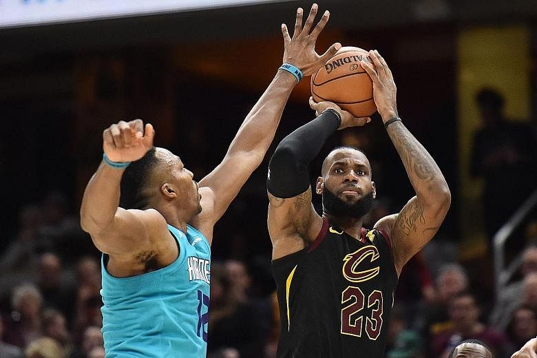 Cleveland Cavaliers forward LeBron James shoots over Charlotte Hornets centre Dwight Howard during the second half at Quicken Loans Arena. James finished with a triple-double as the Cavs won 100-99.