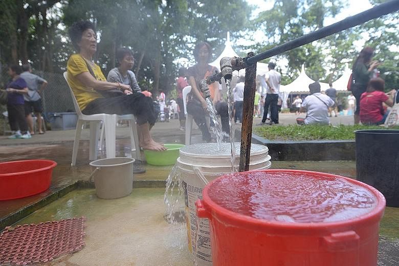 Visitor Ivan Tan trying to boil eggs. NPark's plans include an area with running hot spring water for cooking eggs. Visitors enjoying the hot spring in Sembawang yesterday. In place of the snaking central pipes and taps, there will soon be a cascadin