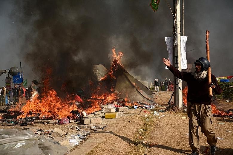 A protester in Islamabad seen near burning tents during clashes with police on Saturday.