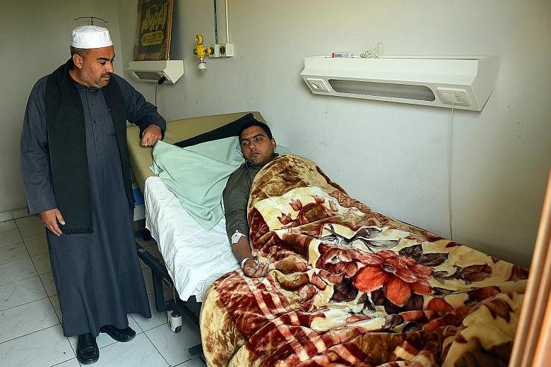 Al-Rawadi Mosque's Imam Mohamed Abdel Fattah (right) receiving treatment at al-Husseiniya hospital in northern Egypt on Saturday.