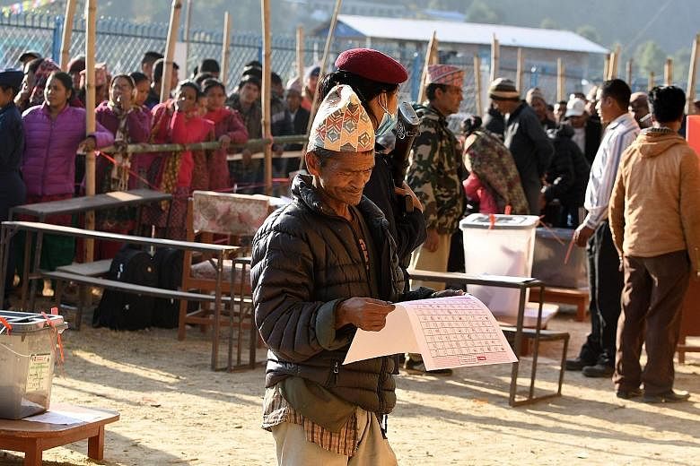 A Nepali voter examining a ballot paper before casting his vote at a polling station in Chautara, about 100km east of Kathmandu, yesterday.