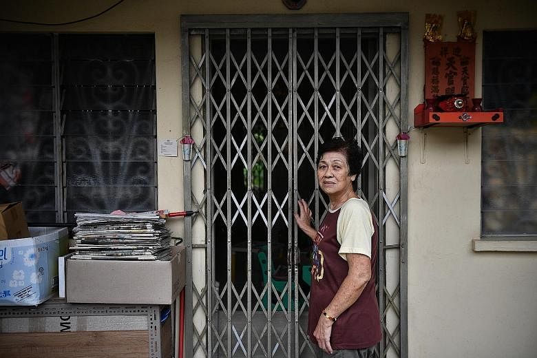 Former hotel worker N.K. Yap, a resident of Stulang Darat, has set up a small gardening area of her own behind the estate. Children in the estate waiting for the bread van. When people hear the horn, those living on the higher floors lower baskets to