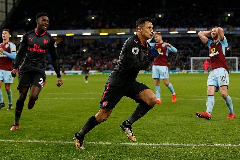 Arsenal's Danny Welbeck (No. 23) steps in to intervene after Burnley's Matthew Lowton clashed with Aaron Ramsey (No. 8) for the latter's part in winning the penalty deep into stoppage time. Arsenal's Alexis Sanchez celebrates after scoring the last-g