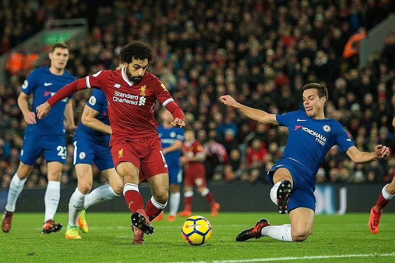Liverpool's Mohamed Salah scoring the opening goal during the English Premier League match between Liverpool and Chelsea at Anfield on Saturday. Chelsea equalised through Willian's unconventional goal in the 85th minute.