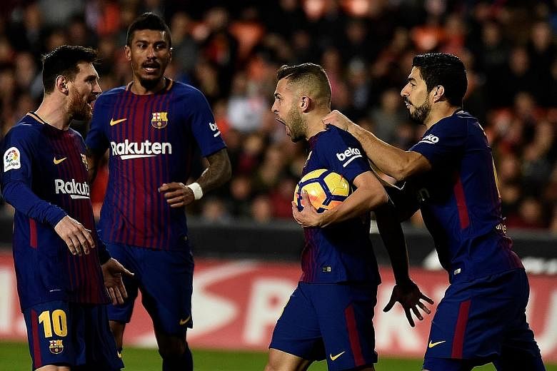 Barcelona left-back Jordi Alba (second from right) celebrating with team-mates Lionel Messi, Paulinho and Luis Suarezafter his 82nd-minute equaliser against former club Valencia on Sunday. The table-toppers maintained their four-point lead over the s