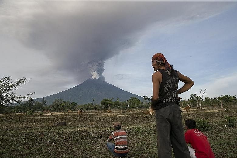 Mount Agung spewing thick ash into the sky, as seen from Datah, Karangasem, in Bali, yesterday. The disaster management agency urged all remaining villagers in the 8km to 10km danger zone to leave. The closure of Ngurah Rai airport could last longer 