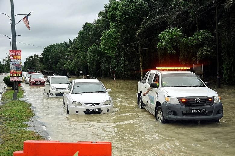 A road in Kuala Terengganu leading into Kota Baru in Kelantan was partly submerged by flood waters on Sunday, following heavy rain in Malaysia's east coast states over two days. Parts of Kelantan and Terengganu states were flooded as rivers broke the
