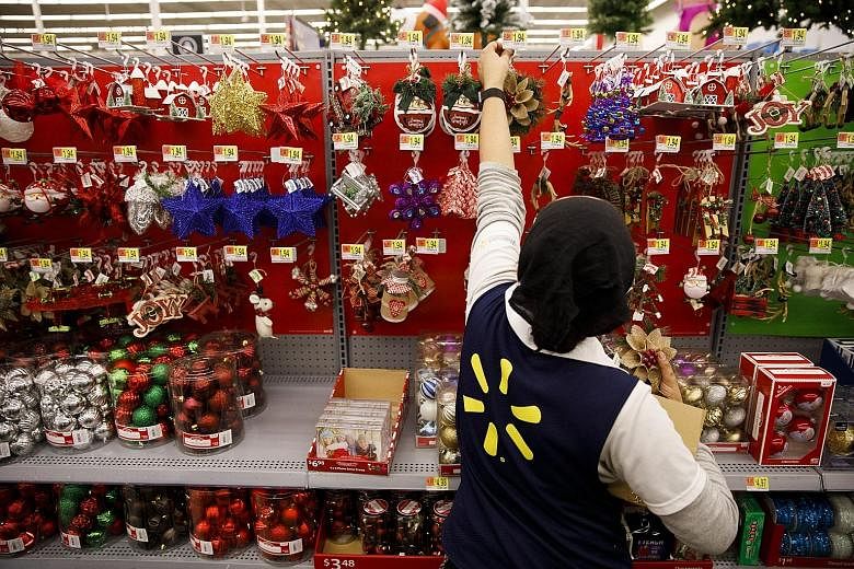 A Wal-Mart employee stocking Christmas ornaments at a store in Burbank, California, on Nov 16, ahead of the US holiday shopping season. The retailer has aggressively invested in making its prices more competitive against brick-and-mortar rivals since