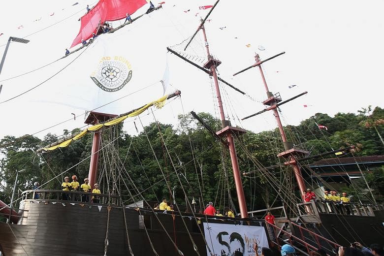 PM Lee unfurling the sail bearing Outward Bound School's crest on board the Indiana in a ceremonial event on Pulau Ubin yesterday.