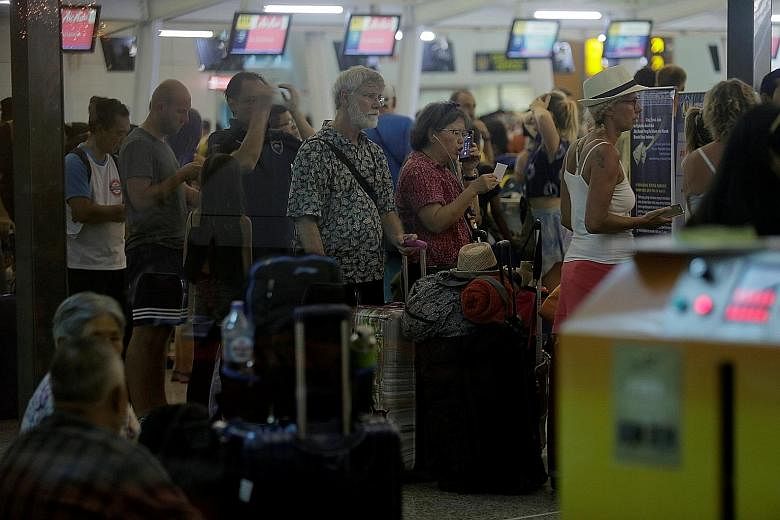 Passengers queueing at a check-in counter after Bali's Ngurah Rai International Airport reopened yesterday. Officials cautioned that the airport could close again depending on the wind direction.