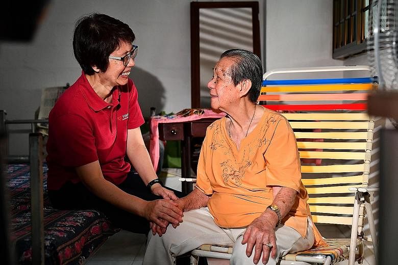 Touch senior social worker Lai Yen Hoon with Madam Cheong Siew Keng at her flat. Ms Lai says the new scheme will help social workers continue to provide care for their charges.