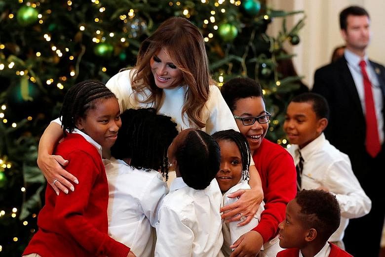 Mrs Melania Trump hugging schoolchildren at the White House on Monday. A report in Vanity Fair said that she was unprepared and had not wanted the role of First Lady.