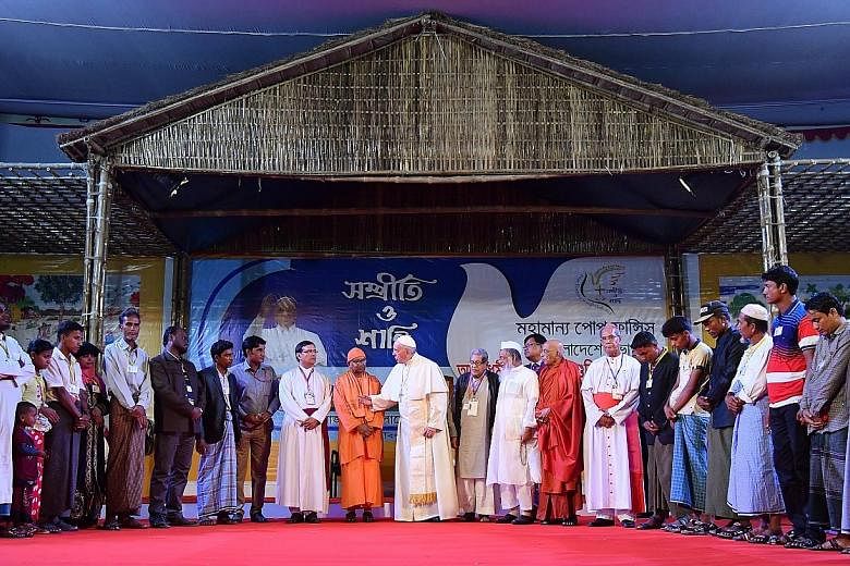 Pope Francis with Rohingya refugees and other members of the clergy during an interreligious and ecumenical meeting for peace in Dhaka, Bangladesh, on Friday. The pontiff yesterday ended his visit of Myanmar and Bangladesh, during which he met some R