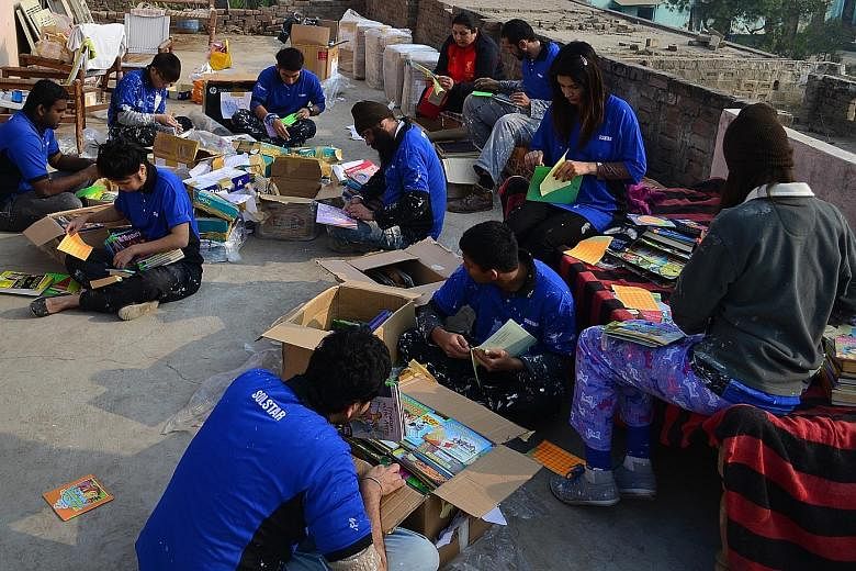 Members of YSA's Project Khwaish sorting out books for the library in a village school in Punjab.