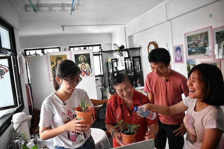 Madam Yee Dew Eng at her new Cassia Crescent home last month with Cassia Resettlement Team members (from left) Lee Wei Ting, 20, Lim Jingzhou, 20, and Ng Xiang Yun, 17. CRT volunteers visit her on Saturdays and help her pack her medication.