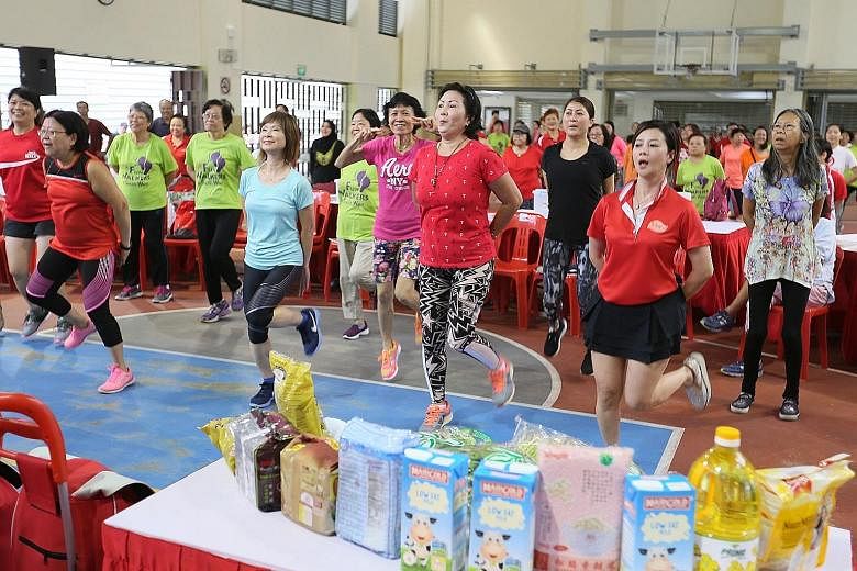 Senior Minister of State Amy Khor (in blue) and Hong Kah North residents performing a series of exercises at the Hong Kah North Community Club yesterday.