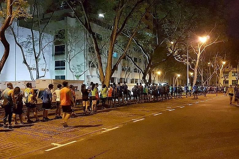 Participants in the Standard Chartered Singapore Marathon queuing to deposit their belongings near Wheelock Place before the race on Sunday. The delay was just one of many glitches runners were unhappy about.