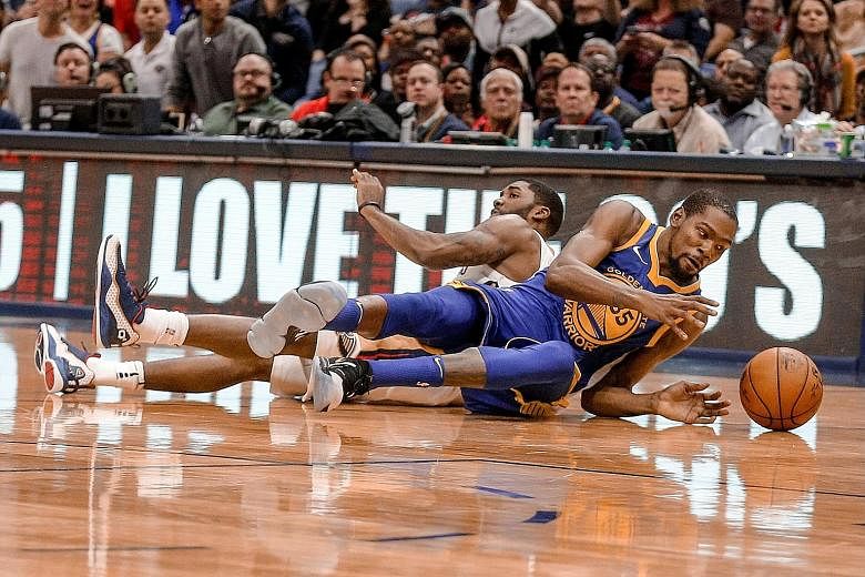 Golden State forward Kevin Durant (right) and New Orleans guard E'Twaun Moore scramble for a loose ball. Durant was later thrown out of the game, which the Warriors won 125-115 after fighting back from 21 points down.