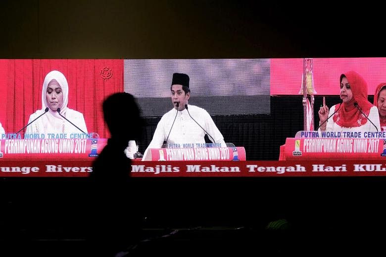 From right: Umno Women's chief Shahrizat Abdul Jalil, Youth chief Khairy Jamaluddin and Puteri chief Mas Ermieyati giving their policy speeches yesterday as shown on a giant screen.