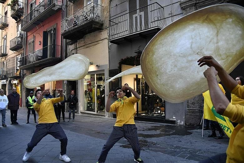 Members of the Pizzaioli Acrobats Coldiretti twirling pizza to celebrate the Unesco decision to make Neapolitan pizzaiuolo an "intangible heritage". The custom goes beyond the handling of dough to include songs and stories that have turned pizza-maki