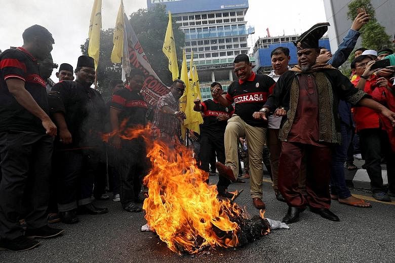Protesters burning an effigy of US President Donald Trump as they marched towards the US Embassy in Kuala Lumpur yesterday. More than 1,000 people thronged one of the busiest roads in the Malaysian capital to demand that Mr Trump retract his decision