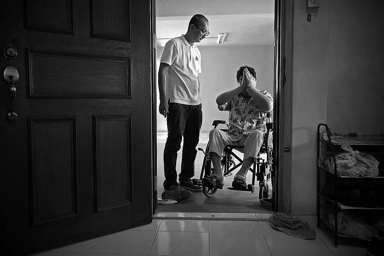 Volunteer Paul Koh looking on as Mr Tay paid his respects to the gods before leaving his sister's flat, during a home visit in October. Volunteer Jaki Fisher, 39, who runs the No One Dies Alone (Noda) project, keeping an eye on Mr Tay during a late-n