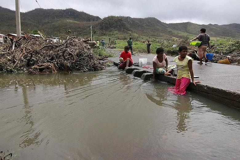 Fiji residents of a settlement damaged by Cyclone Winston last year are shown in this New Zealand Defence Force photo. Worsening extreme weather events have forced entire communities on low-lying Pacific Islands to relocate. There are growing calls f