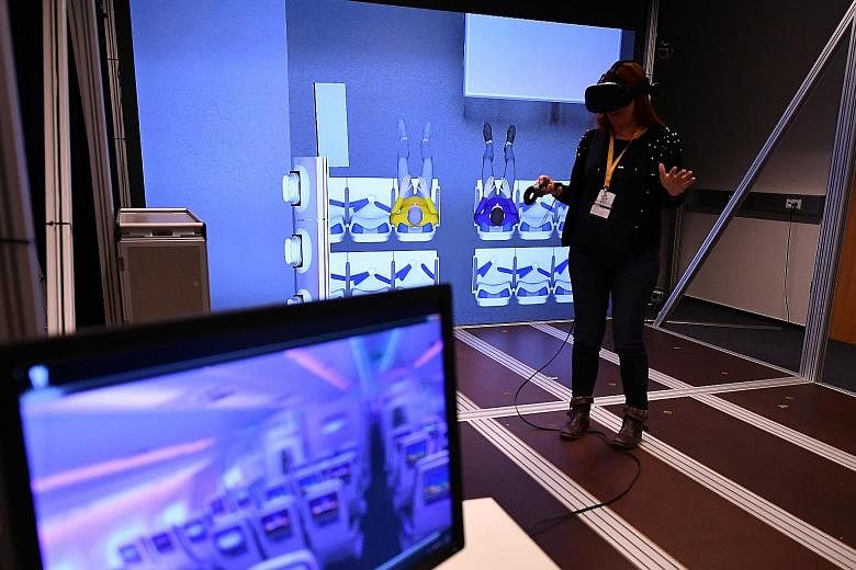 A member of the media trying out Airbus' virtual reality technology at the planemaker's facility in Hamburg yesterday. Customers are now able to take tours of a completed plane before it is even built. The company is also using 3D printing to build a