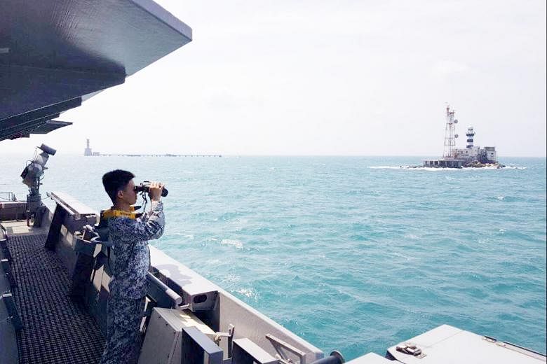 A crew member of RSS Sovereignty scanning the horizon for the missing men. He is looking at Pedra Branca, and Middle Rocks is to his left.