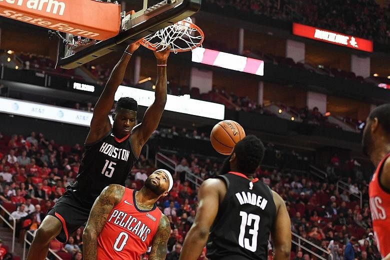Rockets centre Clint Capela dunking over Pelicans centre DeMarcus Cousins at Toyota Center as Rockets guard James Harden watches. Houston remain top of the Western Conference ahead of NBA champions Golden State.