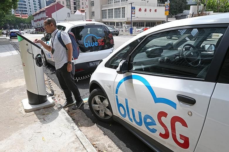 From left: The reporter at one of BlueSG's charging locations in Mohamed Sultan Road and driving the electric car, which is like being at the wheel of a petrol-driven one. The app shows the cost of the journey.