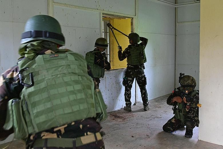 The Philippine soldiers forming up before an assault on the buildings. The two-hour-long exercise in Lim Chu Kang yesterday was the culmination of a two-week exchange programme between the Philippine and Singapore armed forces.